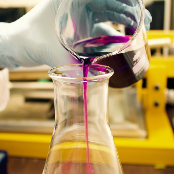 Ionic Liquids image showing chemical in liquid form being poured into laboratory glassware.